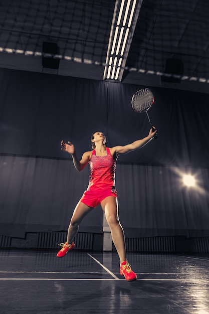 Jonge vrouw badminton spelen over gymruimte