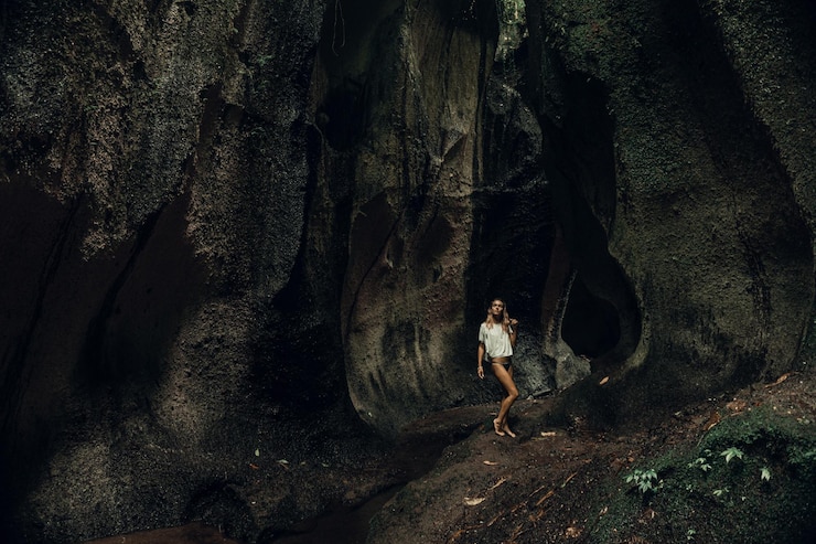 Gratis Foto jonge vrouw bij de waterval in de rots bali indonesië