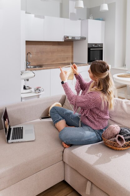 Jonge vrouw breit terwijl u ontspant