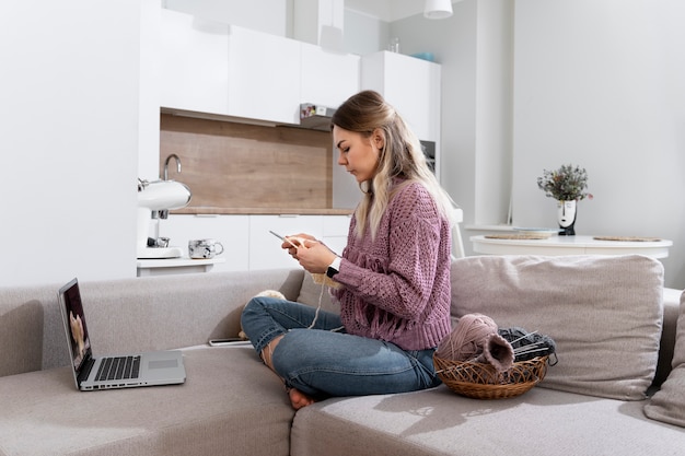 Gratis foto jonge vrouw breit terwijl ze ontspant