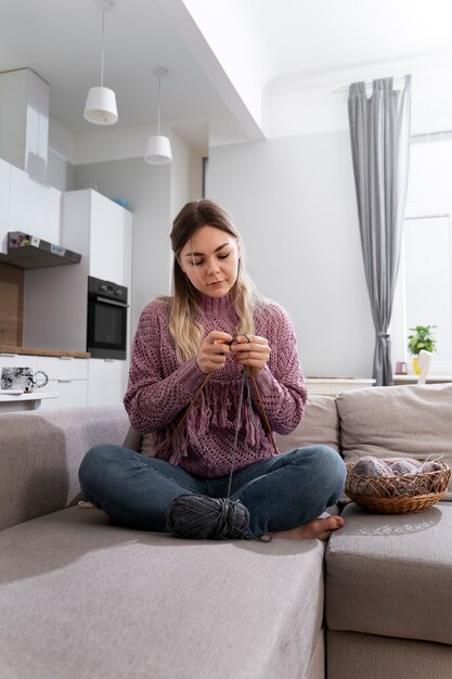 Jonge vrouw breit terwijl ze ontspant