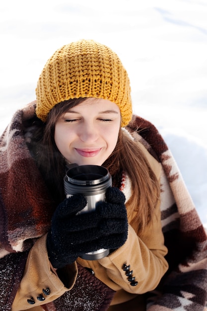 Jonge vrouw buiten het drinken van warme drank