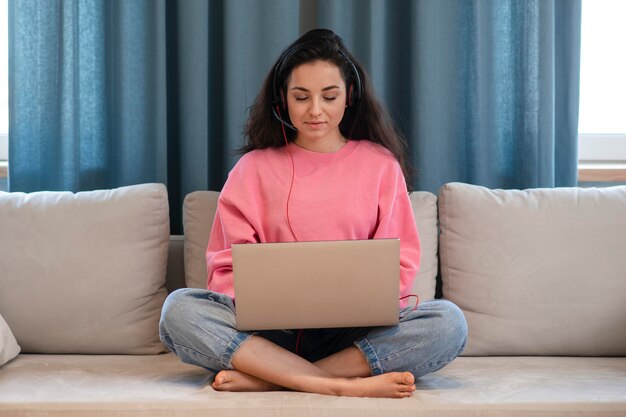 Jonge vrouw die aan laptop thuis werkt