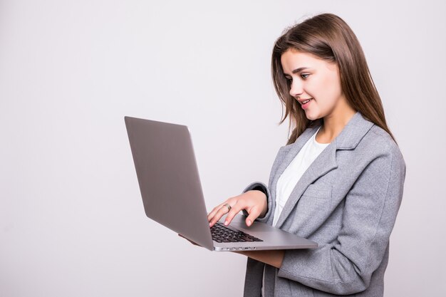 Jonge vrouw die aan laptop werkt die op witte achtergrond wordt geïsoleerd