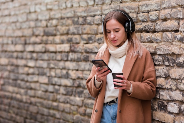 Jonge vrouw die aan muziek op hoofdtelefoons met exemplaarruimte luistert