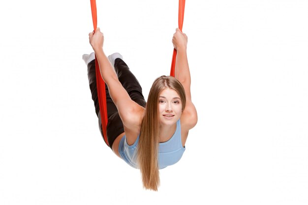 Jonge vrouw die anti-zwaartekracht luchtyoga doet