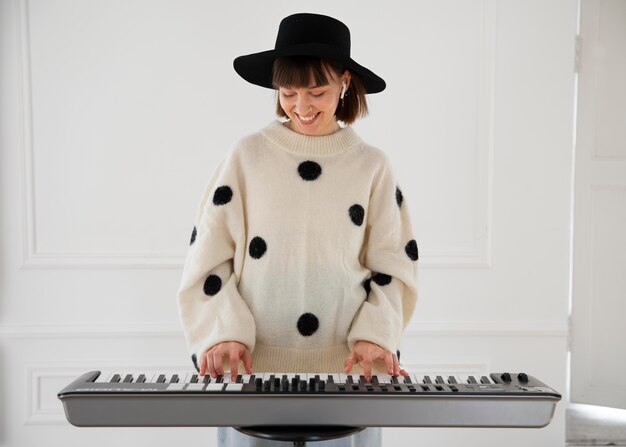 Jonge vrouw die binnen piano speelt