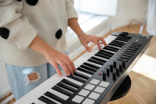 Gratis foto jonge vrouw die binnen piano speelt