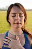Gratis foto jonge vrouw die buiten mediteert