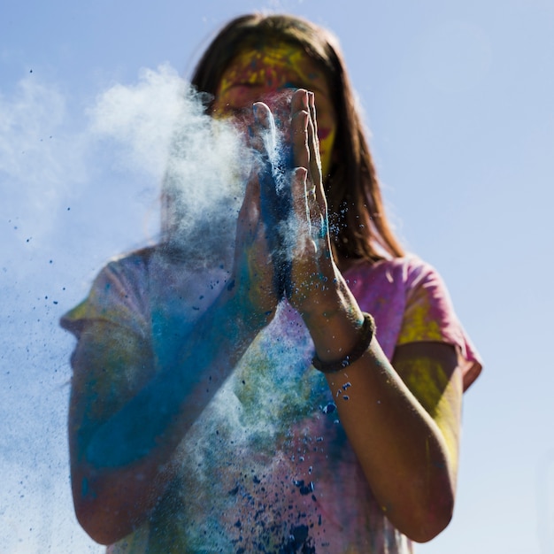 Jonge vrouw die de blauwe holikleur met handen bestrooit