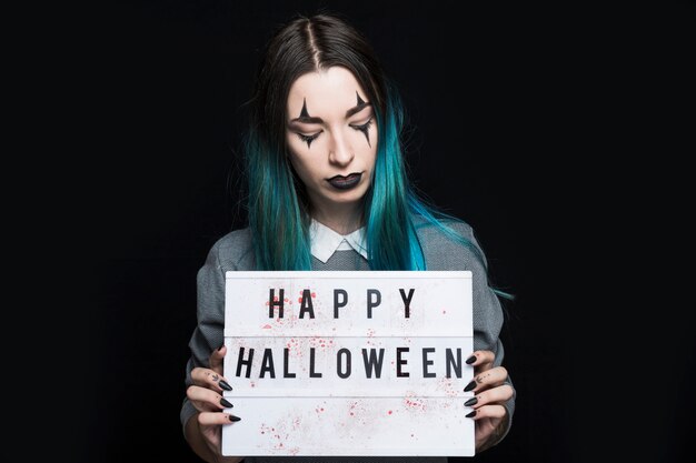 Jonge vrouw die de Gelukkige inschrijving van Halloween toont