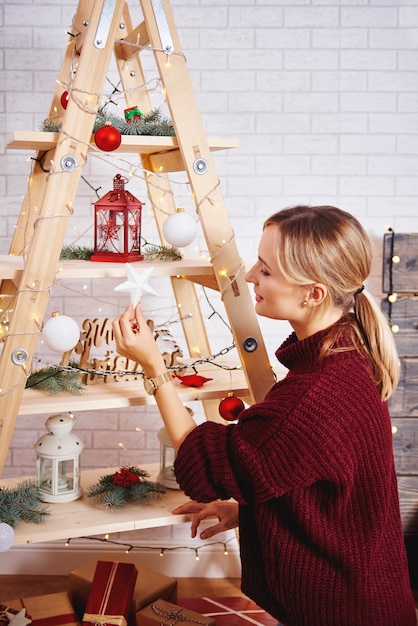 Jonge vrouw die de kerstboom verfraait