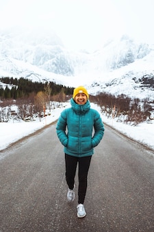 Jonge vrouw die de weg op wandelt in noorwegen