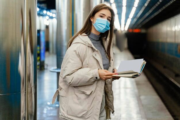 Jonge vrouw die een boek in een metrostation leest