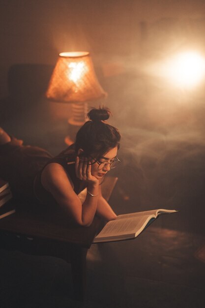 Jonge vrouw die een boek thuis leest