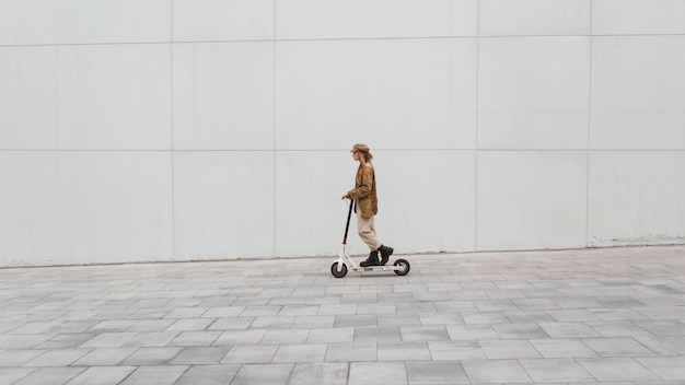 Jonge vrouw die een elektrische autoped berijdt