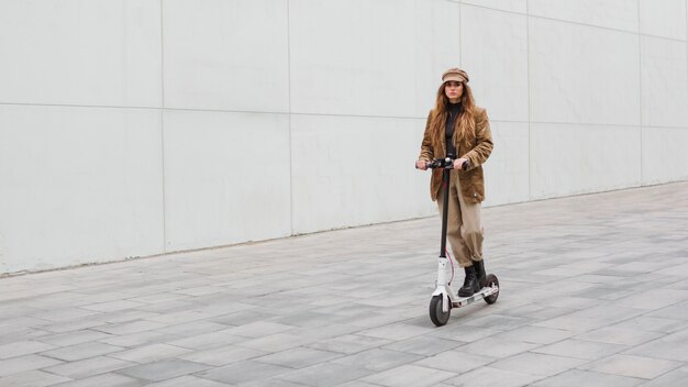 Jonge vrouw die een elektrische autoped berijdt