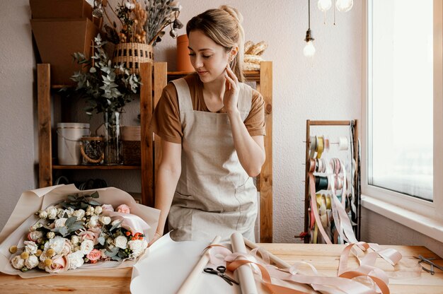 Jonge vrouw die een mooie bloemenregeling maakt