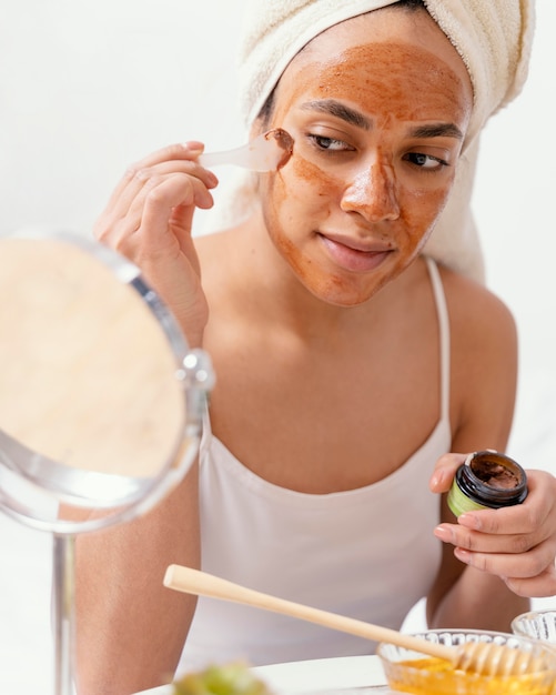 Gratis foto jonge vrouw die een natuurlijk gezichtsmasker toepast