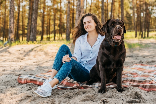 Gratis foto jonge vrouw die een picknick met haar hond doet