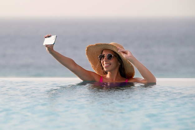 Jonge vrouw die een selfie maakt met haar smartphone in vakantie