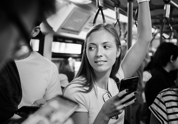 Jonge vrouw die een smartphone in de metro gebruikt