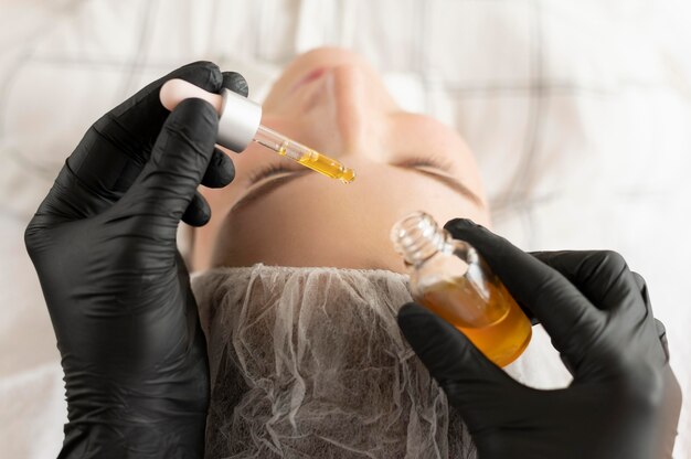 Jonge vrouw die een wenkbrauwbehandeling krijgt bij de schoonheidssalon