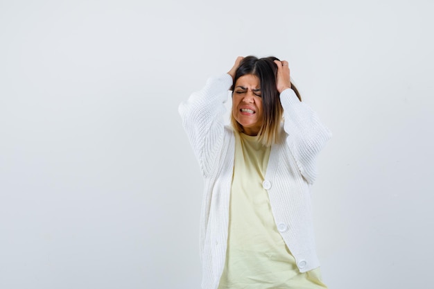 Jonge vrouw die een wit vest draagt en gestrest is