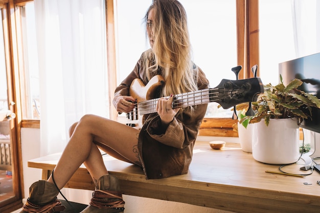 Jonge vrouw die elektrische gitaar legt