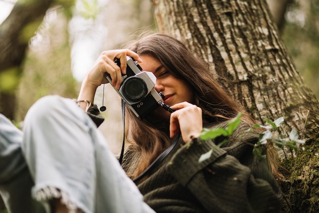 Jonge vrouw die foto in aard neemt