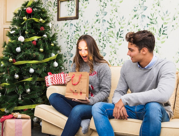 Jonge vrouw die glanzende giftzak bekijkt