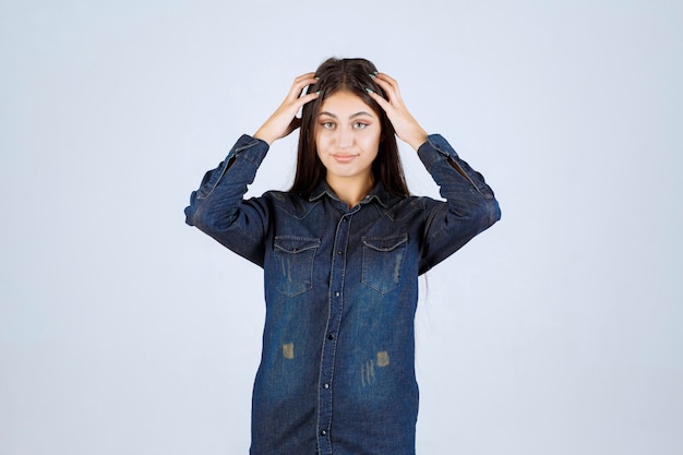 Jonge vrouw die haar hoofd houdt en denkt