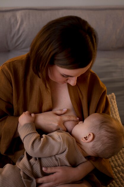 Jonge vrouw die haar schattige baby borstvoeding geeft