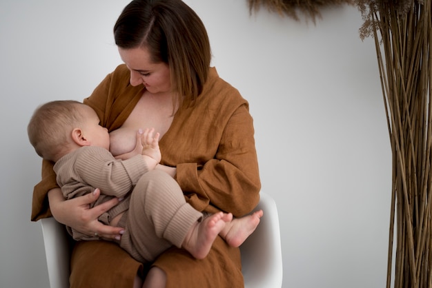 Jonge vrouw die haar schattige baby borstvoeding geeft