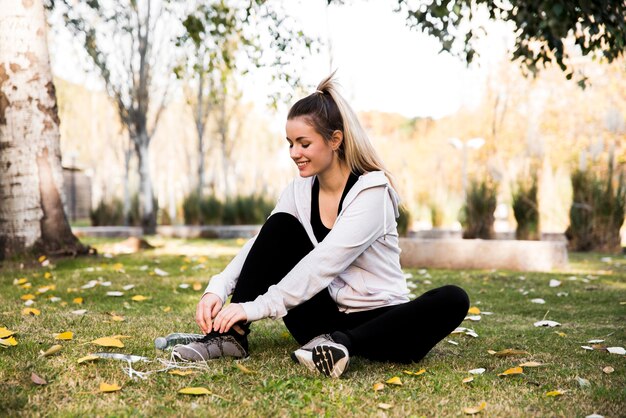 Jonge vrouw die haar tennisschoenen