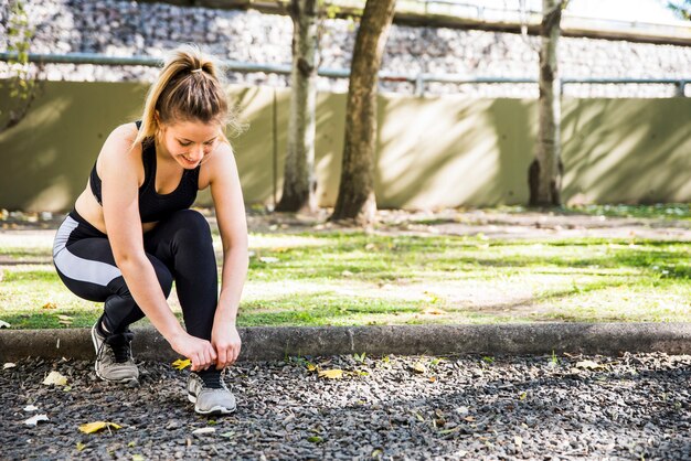 Jonge vrouw die haar tennisschoenen