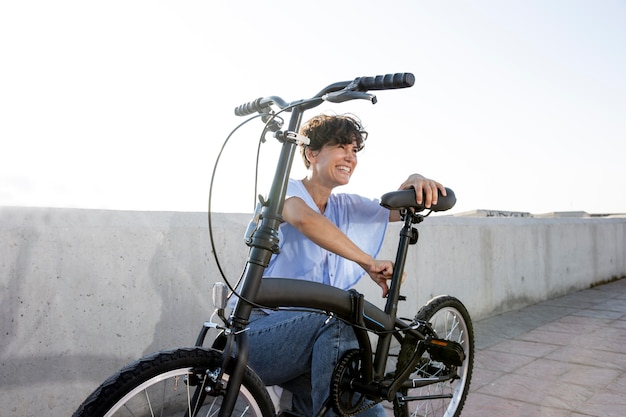 Gratis foto jonge vrouw die haar vouwfiets gebruikt