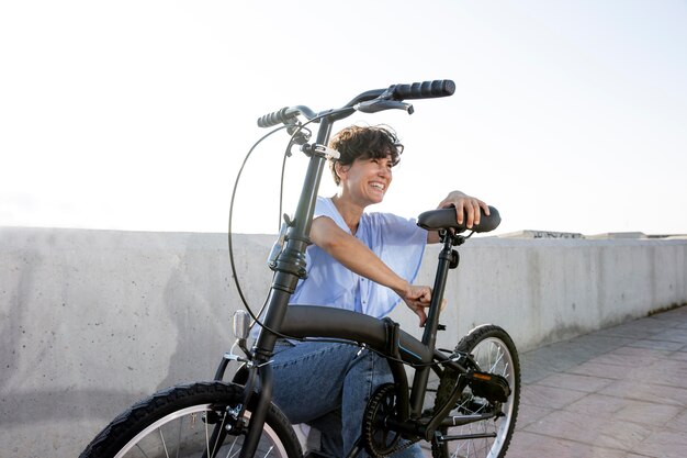 Jonge vrouw die haar vouwfiets gebruikt