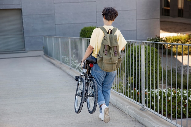 Gratis foto jonge vrouw die haar vouwfiets gebruikt