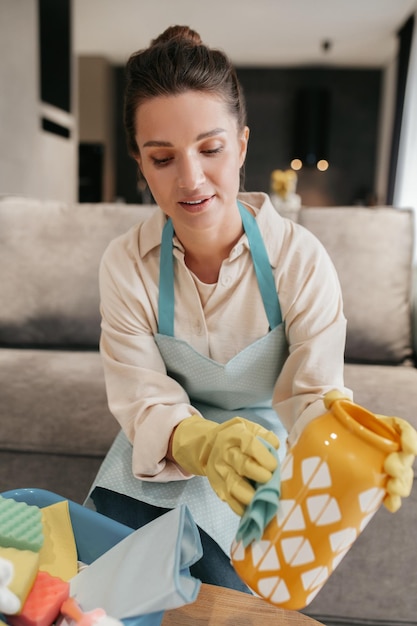 Gratis foto jonge vrouw die huishoudelijk werk doet en er druk uitziet