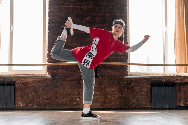 Jonge vrouw die in dansstudio danst