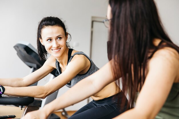 Gratis foto jonge vrouw die in de gymnastiek uitwerkt