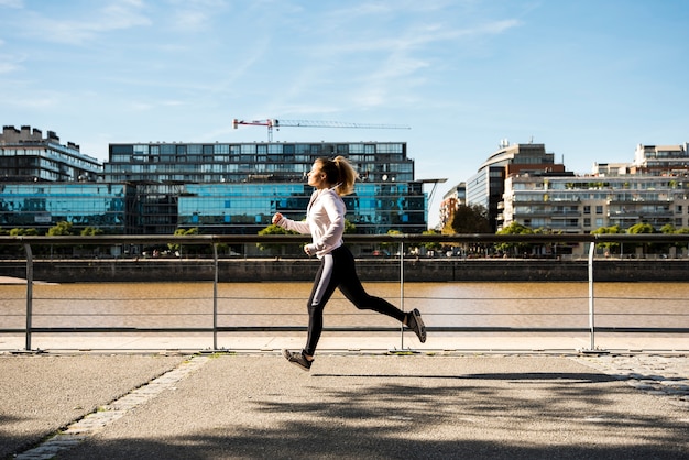 Gratis foto jonge vrouw die in openlucht met sportkleding loopt