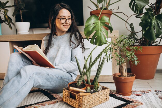 Jonge vrouw die installaties thuis cultiveren