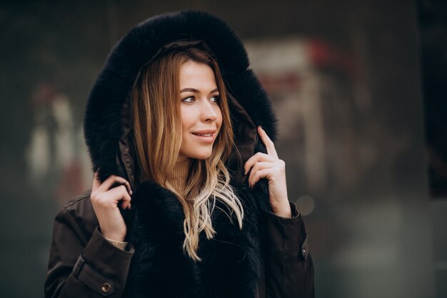 Jonge vrouw die jasje draagt die buiten loopt