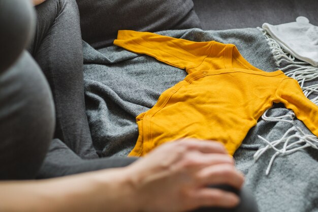 Jonge vrouw die kleren voor baby voorbereidt