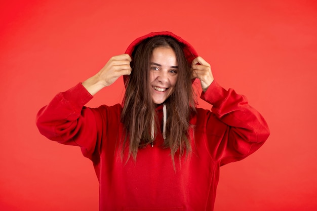 Jonge vrouw die lacht geïsoleerd op rood