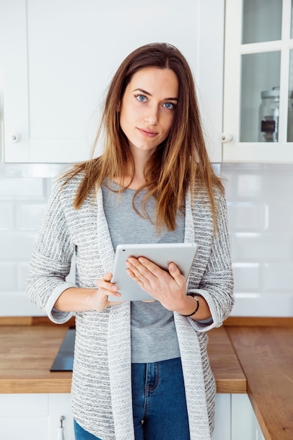 Gratis foto jonge vrouw die met tablet camera bekijkt