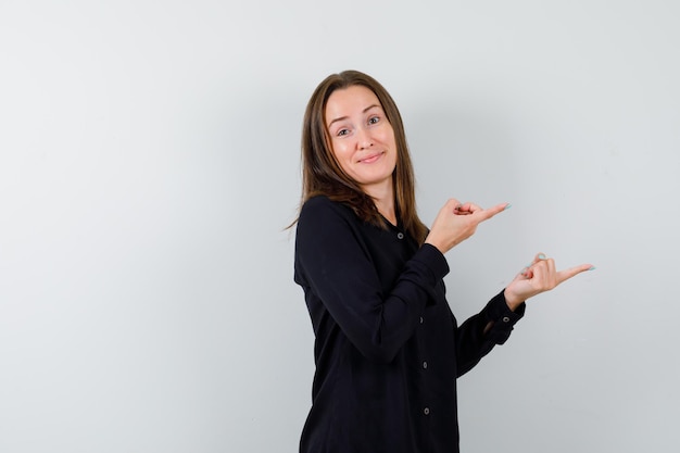 Jonge vrouw die naar rechts wijst en er verward uitziet