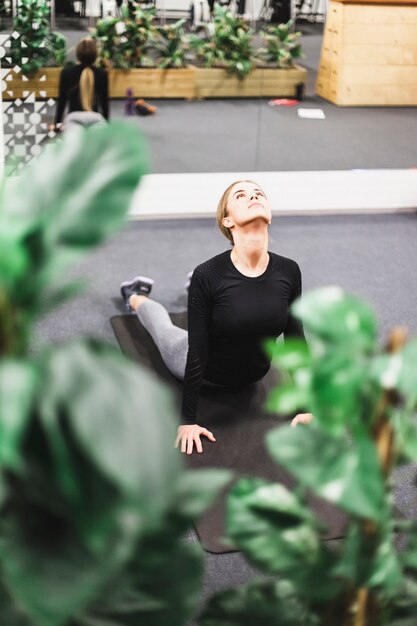 Jonge vrouw die oefening in gymnastiek doet